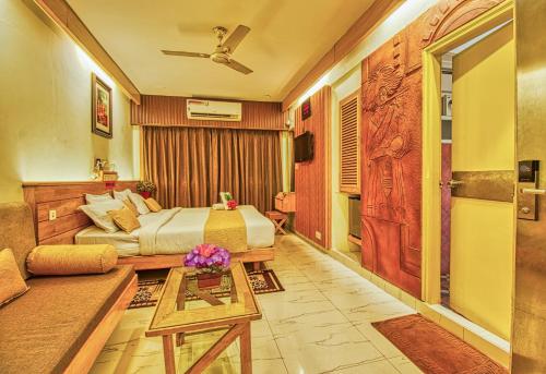 a hotel room with a bed and a couch at Parklane Hotel in Mysore