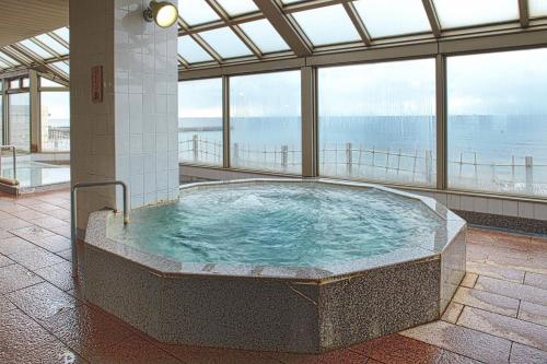 bañera de hidromasaje en un edificio con vistas al océano en Yunohama Hotel, en Hakodate