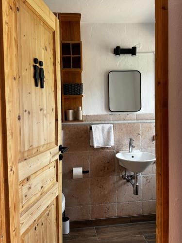 a bathroom with a sink and a tv on the wall at Garden Eden & Sauna in Neumagen-Dhron