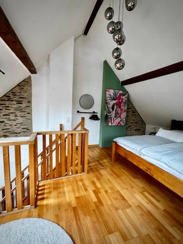 a bedroom with a bed and a wooden floor at Garden Eden & Sauna in Neumagen-Dhron