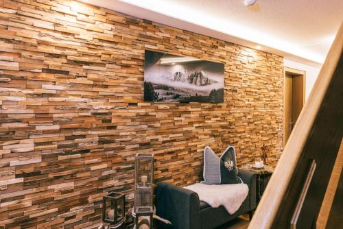 a living room with a brick wall with a tv at Landhaus Perktold in Nesselwängle