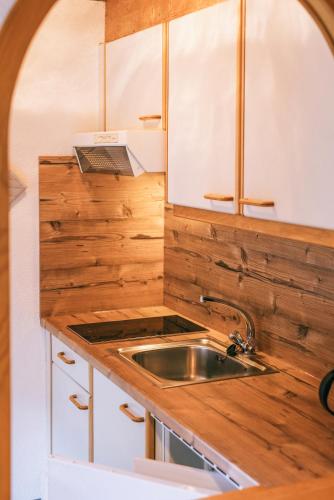 a kitchen with a sink and a laptop on the counter at Landhaus Perktold in Nesselwängle