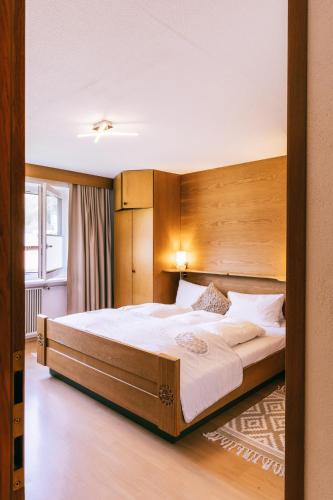 a bedroom with a large bed with a wooden headboard at Landhaus Perktold in Nesselwängle