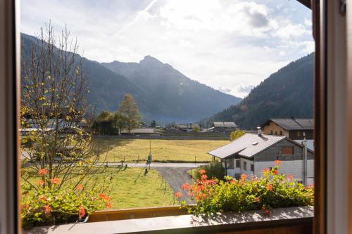 a view of a valley from a window with flowers at Landhaus Perktold in Nesselwängle