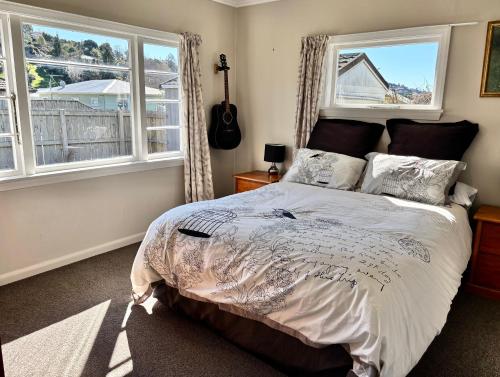ネルソンにある3-Beds with Sunny Deck & Gardensのベッドと2つの窓がある寝室
