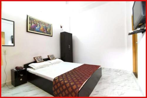 Un dormitorio con una cama y un televisor en la pared. en HOTEL D-S - RESIDENCY - Near Kasi Vishwanath Temple #Fully Air Conditioning -Free Wifi -Parking -Room Service #Best Hotel In Varanasi, en Varanasi