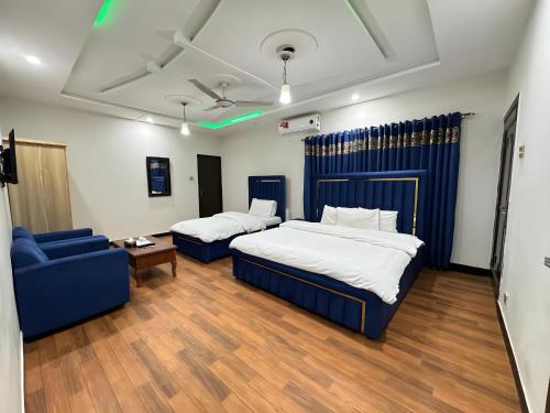 a bedroom with two beds and a blue couch at Decent Luxury Continental in Islamabad