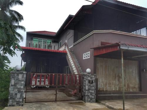 a house with a red gate in front of it at Homestay Bajet Rantau Panjang 