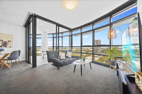 a living room with a couch and a table at Fabulous view apartment in Sydney Olympic Park in Sydney
