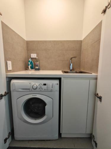 a laundry room with a washing machine and a sink at Fabulous view apartment in Sydney Olympic Park in Sydney