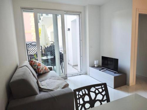 ein Wohnzimmer mit Sofa und Fernseher in der Unterkunft Charm Home Alassio in Alassio