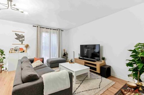 a living room with a couch and a tv at Maison avec jardin - entre Paris et Disney in Pontault-Combault