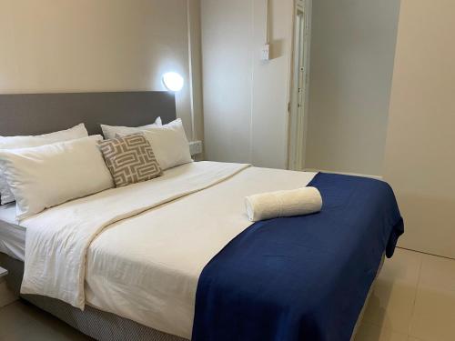 a bedroom with a large bed with a blue blanket at JH Guest house in Durban