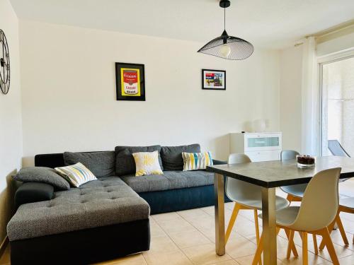 a living room with a couch and a table at appartement au coeur de Saint-Florent à 200m de la plage in Saint-Florent