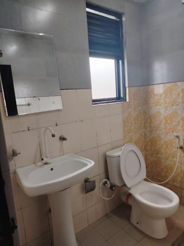 Un baño con un inodoro blanco y un lavabo. en Hotel EESTEE, en Colombo