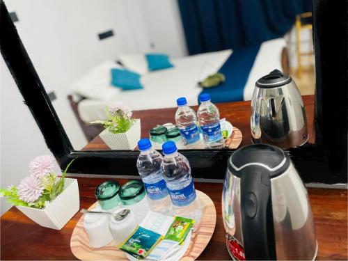 una mesa con botellas de agua y una cafetera en Hotel EESTEE, en Colombo