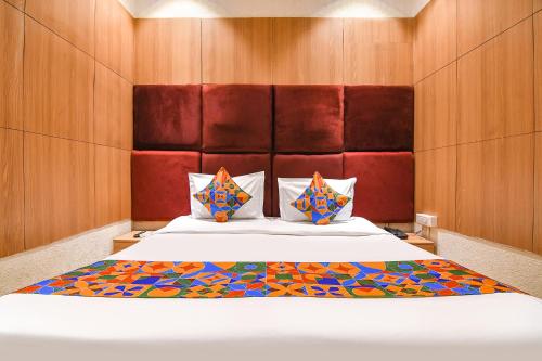 a bedroom with a large bed with wooden walls at FabHotel Marina in Tangra