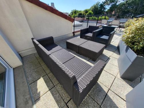 a group of chairs and tables on a patio at Aparthotel Des 2 Caps in Ambleteuse