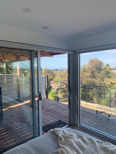 a room with sliding glass doors looking out onto a deck at Guest house - Ocean views in Rye