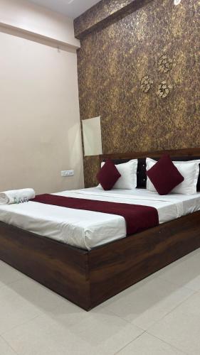 a bedroom with a large bed with red pillows at Raghukulam By R K Palace Ayodhya Dham in Ayodhya