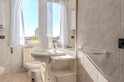 a bathroom with a sink and a toilet and a window at Road to Venice M&N Dolo Apartment in Dolo