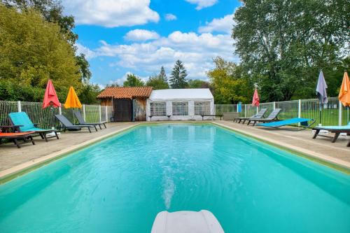 a swimming pool with chairs and a gazebo at Gite Le Pont in Varaignes