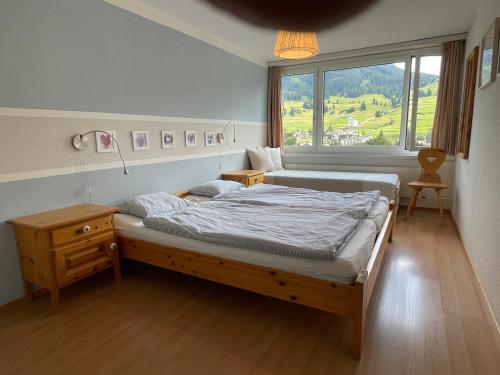 a bedroom with a bed and a window at Tgesa Sunnmatt Nr 11 in Savognin