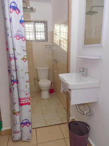 a bathroom with a toilet and a sink at Escape Hole in Diani Beach