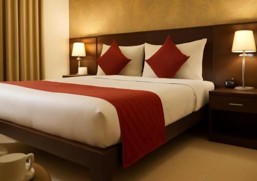a hotel room with a large bed with red pillows at Atlas Inn Stay Near IGI Airport T3 in New Delhi