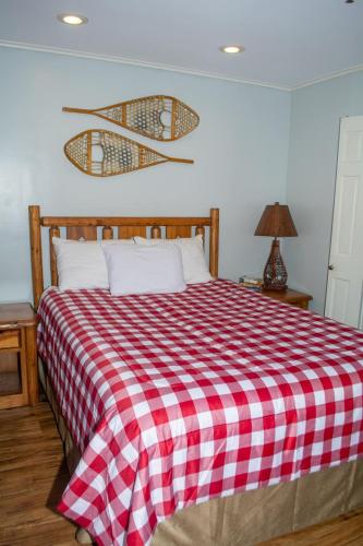 a bed with a red and white checkered blanket at Winterplace Ski In Ski Out First Floor D104 in Ghent