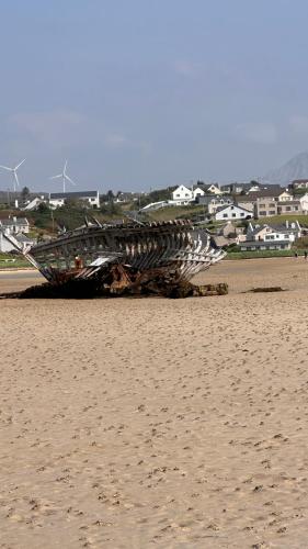a large object laying on the sand on a beach at Four bedroomed Townhouse in Letterkenny