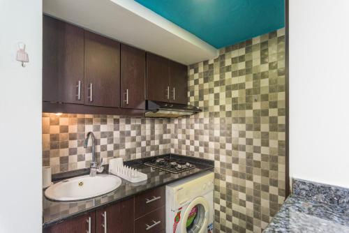 a kitchen with a sink and a washing machine at Bliss Aqua 10 - One BR Chalet at Aqualand Resort in Batroun in Ed Daourâ