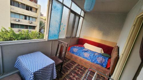 a small room with a bed and a table and windows at Private Room Central, Quite & Beautiful Flat in Cairo