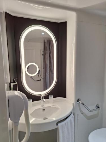 a white bathroom with a sink and a mirror at ibis Bayeux Port En Bessin in Port-en-Bessin-Huppain