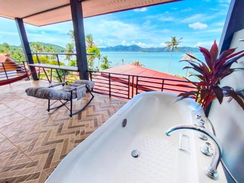 a bath tub in a bathroom with a view of the ocean at Leam Sai Bungalows Koh Yao Noi in Ko Yao Noi