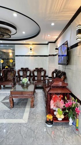 a lobby with chairs and a table and a tv at Victory Hotel 153-155 in Ho Chi Minh City