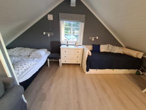 a attic bedroom with a bed and a window at Charming studio apartment in Skarvedalen