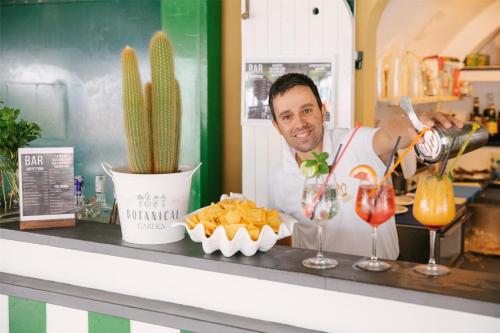 a man standing behind a counter with chips and a drink at Best Western Regina Elena in Santa Margherita Ligure