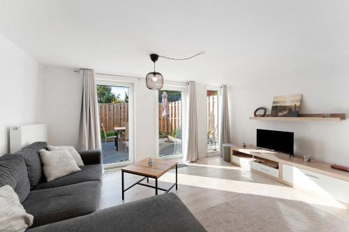 a living room with a couch and a tv at Küstenliebe-Fehmarn in Fehmarn