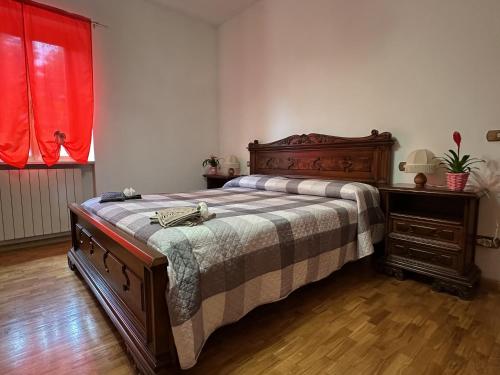 a bedroom with a bed and a dresser and a red window at La locanda del Grottino in Torgiano