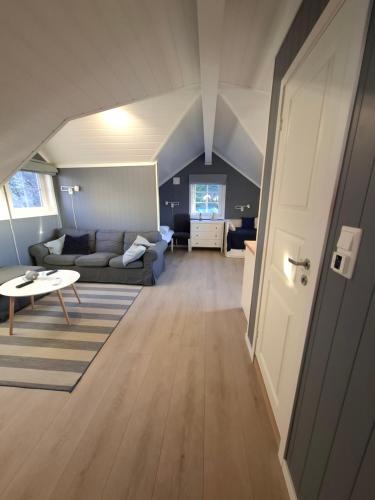 a living room with a couch and a table at Charming studio apartment in Skarvedalen