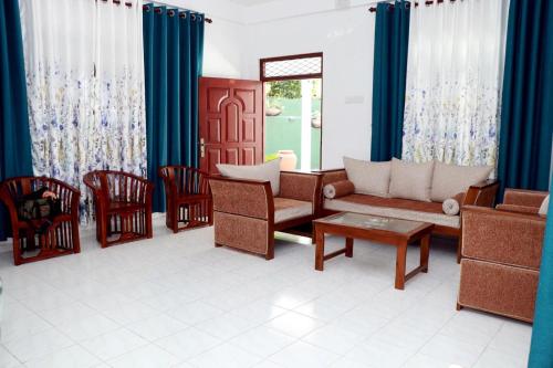 Una sala de estar con un sofá y sillas y una mesa. en ASA VILLA Dickwella, en Dikwella