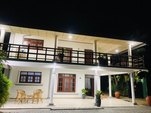 una casa con un balcón con una mesa y sillas en ASA VILLA Dickwella, en Dikwella
