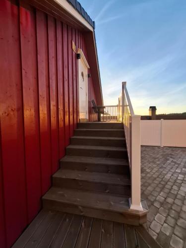 a staircase leading to a red building with a red wall at Charming studio apartment in Skarvedalen