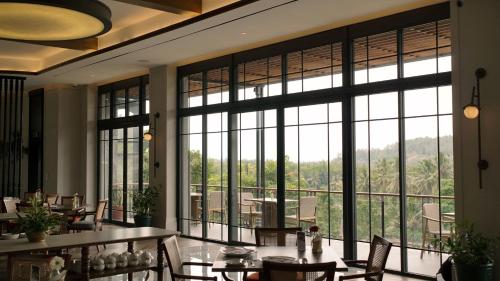 a room with a large window with tables and chairs at Plataran Borobudur in Borobudur