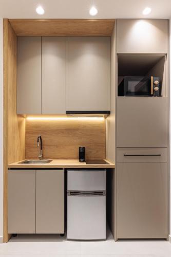 a kitchen with white cabinets and a sink at Dialetti's Nook In Ελλάδα in Thessaloniki