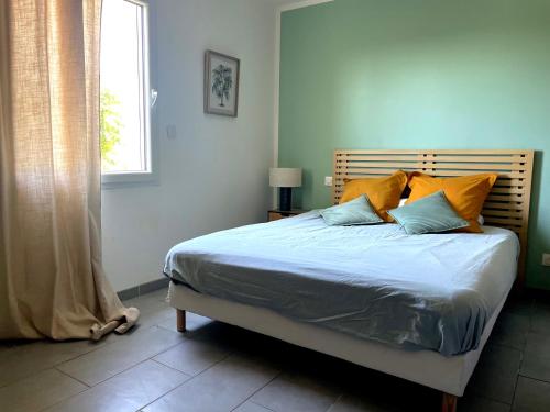 a bedroom with a bed with blue sheets and a window at villa Emilie in Trélissac