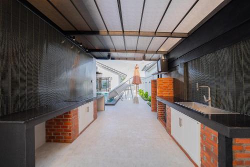 a kitchen with black counters and a sink and a hallway at White berry pool villa aonang in Krabi town
