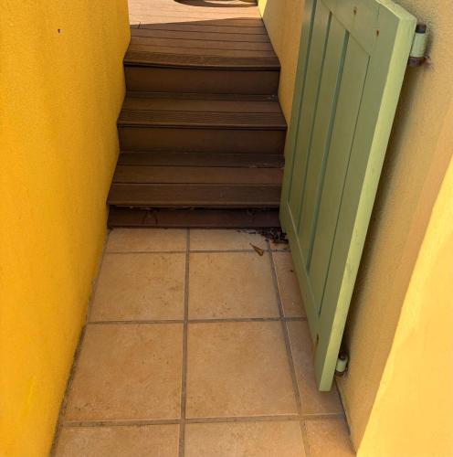 a stairway with a green door next to a staircase at BORD DE MER in Port Leucate