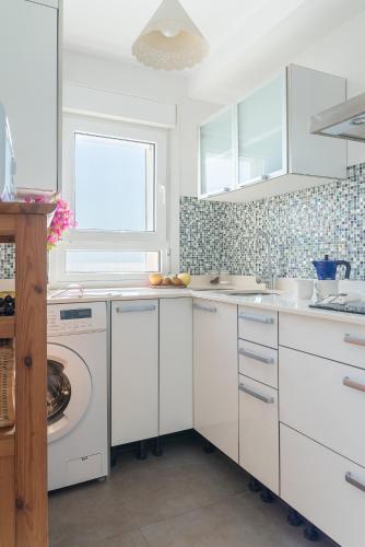 a white kitchen with a washing machine in it at La Casita Masahug in San José